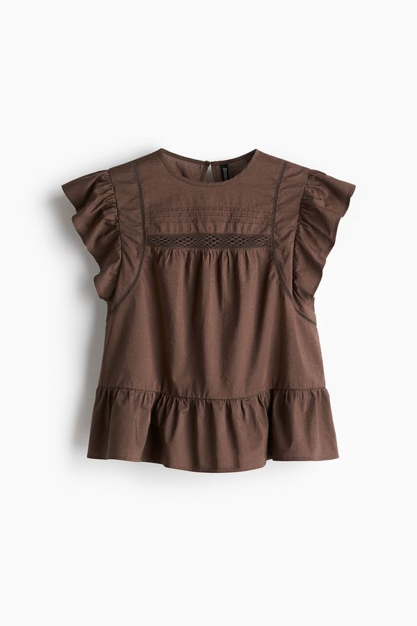 Blusa con inserciones de encaje y peplo
